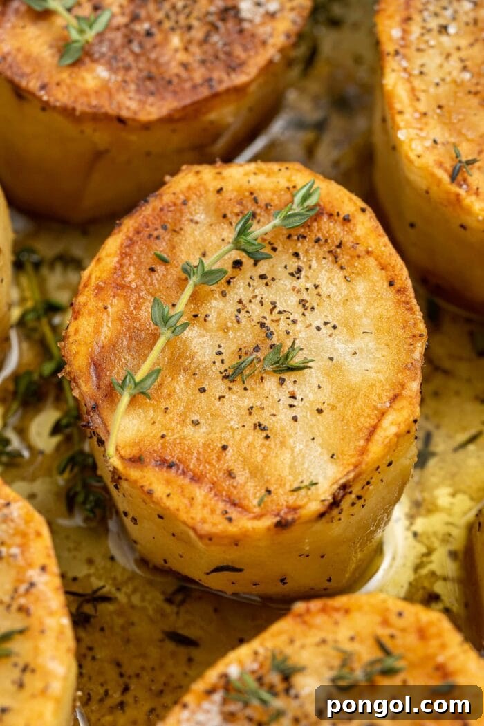 Golden Glazed Fondant Potatoes 3 Close-up of perfectly seared golden-brown fondant potatoes resting in a cast-iron skillet, ready for the oven.