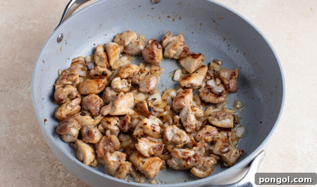 Rich and Creamy Peanut Chicken 7 Browned chicken pieces with onion in a large skillet