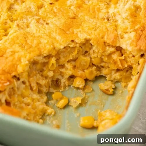 Angled photo of corn souffle with a scoop missing from the corner to show the inside of the souffle