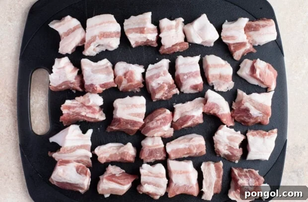Crispy Grilled Pork Belly Bites 7 Raw pork belly cut into uniform cubes on a cutting board.