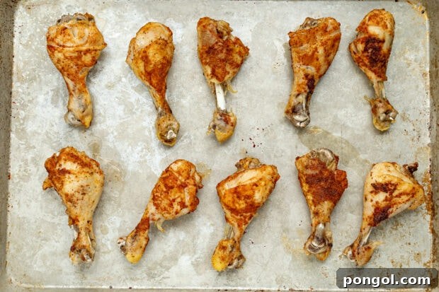 Broiled chicken legs on a baking sheet