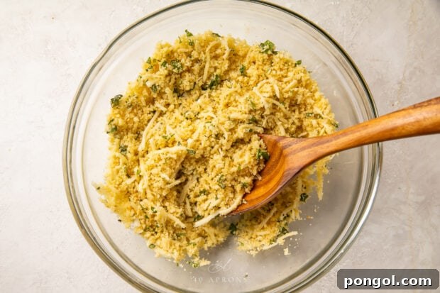 Stuffed tomato filling in a large glass bowl, mixed with a wooden spoon