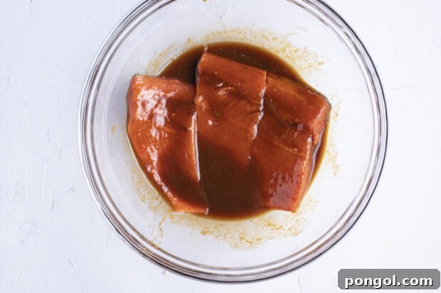 Perfect Miso Glazed Salmon 7 Salmon fillets submerged in the miso marinade within a large glass bowl, ready for refrigeration.