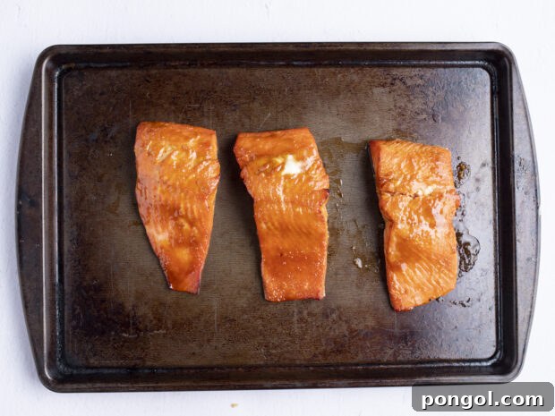 Perfect Miso Glazed Salmon 9 Miso salmon fillets sizzling under the broiler on a baking sheet, showing a developing golden crust.