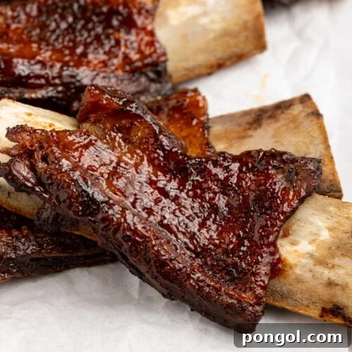 Delicious BBQ beef back ribs on a sheet of parchment paper, ready to be served and enjoyed.