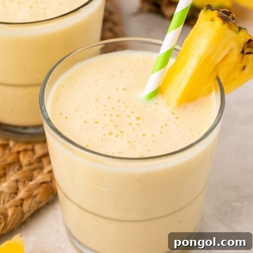 Tropical Pineapple Bliss 4 Short glasses of pineapple smoothie with a pineapple wedge garnish