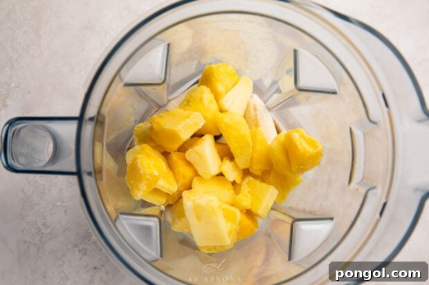 Tropical Pineapple Bliss 6 Ingredients for a pineapple smoothie in a blender, showing the blending process.