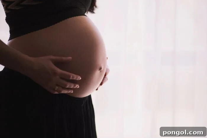 Pregnant woman with hands on belly - natural epidural birth. This image conveys the journey and anticipation of childbirth.