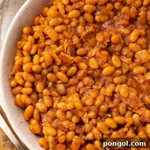 Overhead photo of Instant Pot baked beans in a white bowl on a wooden board