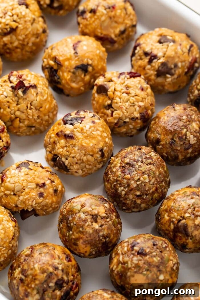 Rows of seed cycling balls on parchment paper, showcasing their appealing texture and vibrant mix-ins.