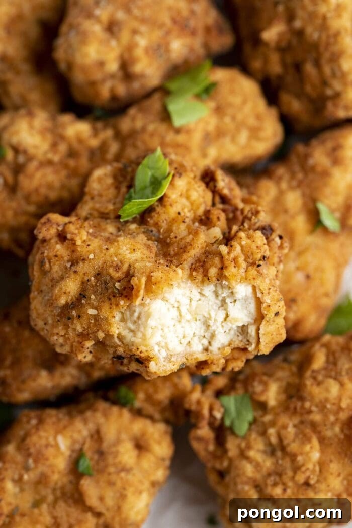 Vegan Fried Tofu Chik'n 2 Crispy golden vegan fried chicken made from tofu on a plate, ready to be served.