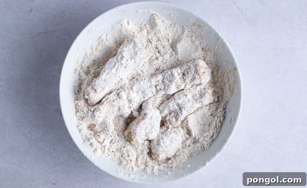 Vegan Fried Tofu Chik'n 9 Tofu in breading mixture in white bowl