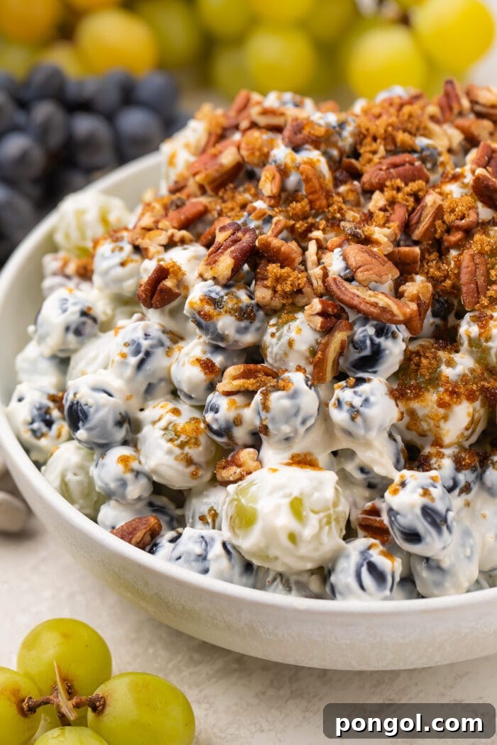 Creamy grape salad topped with pecans and brown sugar, close up