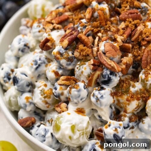 Creamy grape salad topped with pecans and brown sugar