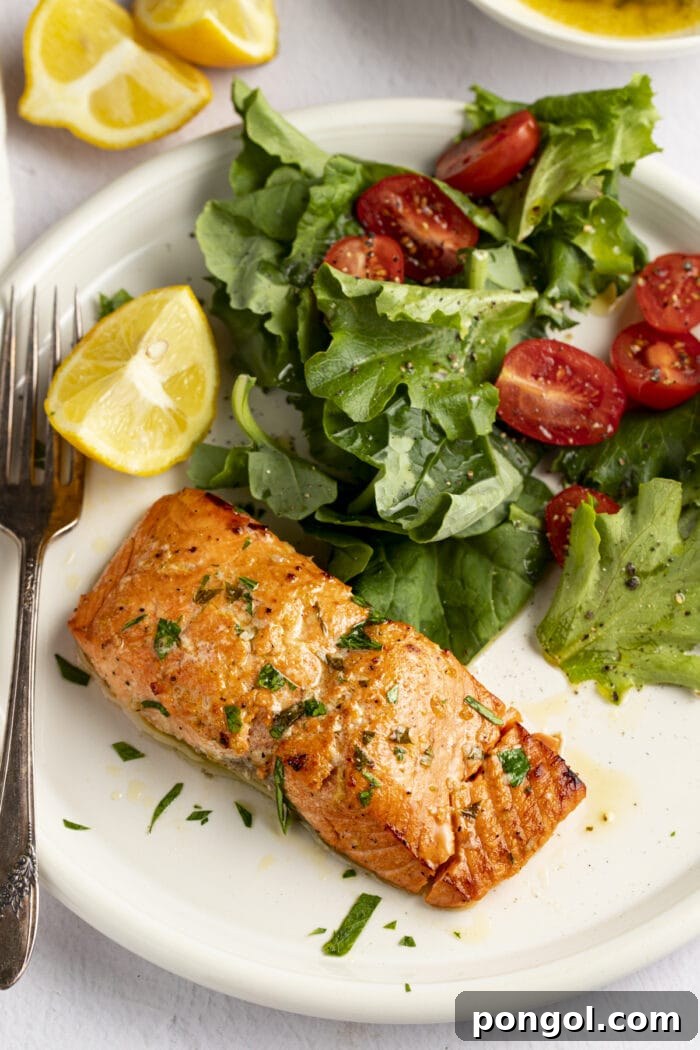 Two beautifully broiled salmon fillets on a baking sheet, showcasing their perfectly crispy skin and tender texture, ready to be served.