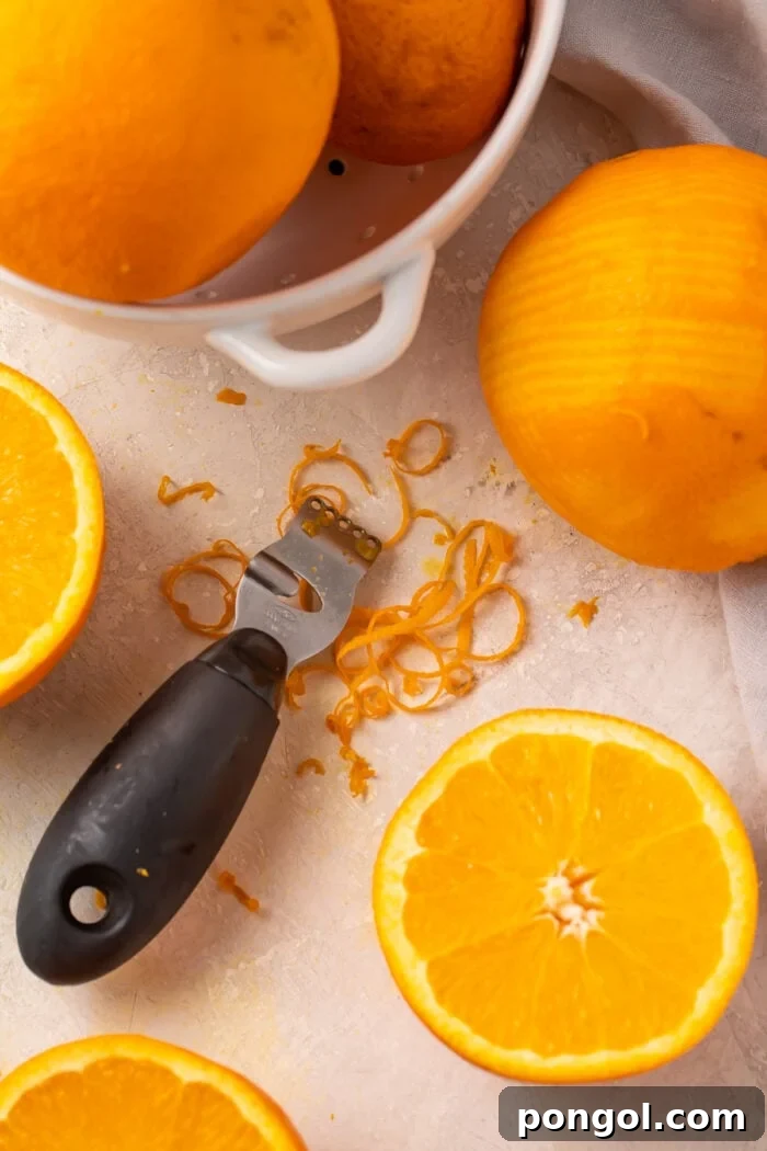 Oranges being zested with a microplane and a traditional zester