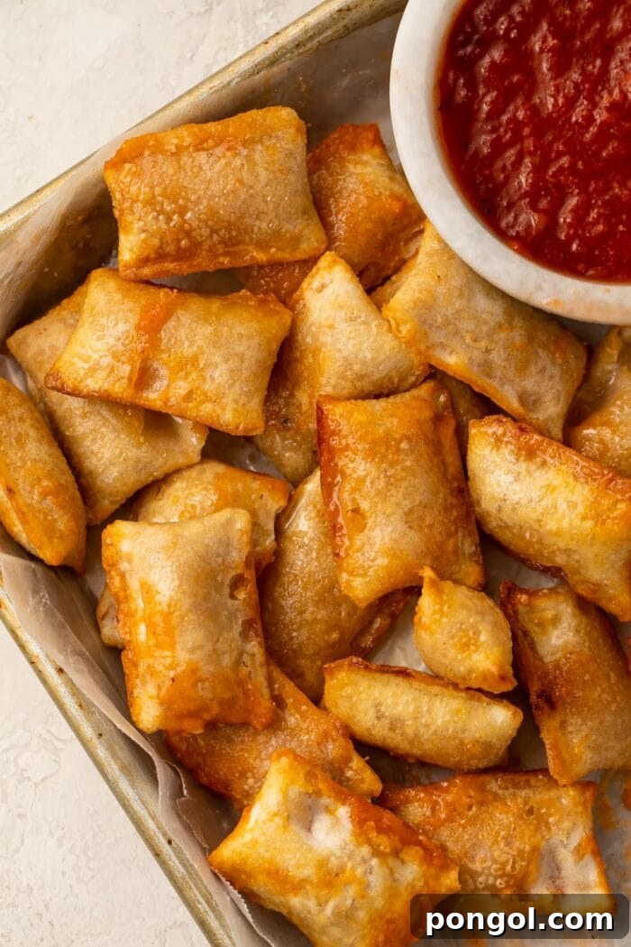 Perfectly cooked crispy pizza rolls served on a white plate next to a small bowl of rich red pizza dipping sauce.