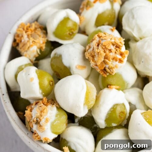 Frozen yogurt-covered grapes with granola in a bowl