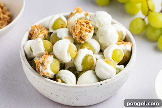 A serving of frozen yogurt-covered grapes with granola in a bowl, capturing the delicious and chilled final product.
