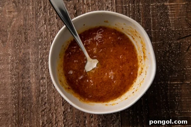 Golden Coconut Chicken with a Zingy Orange-Horseradish Glaze 6 Orange-horseradish sauce in a small bowl with a spoon on a wooden table
