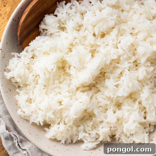 Overhead photo of Instant Pot jasmine rice in a bowl on a wooden tray with a cloth napkin