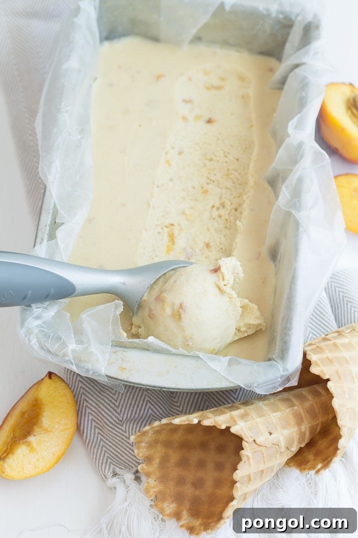 Close-up of vegan peach ice cream in a small bowl, highlighting its inviting color and texture, perfect for a sunny day.