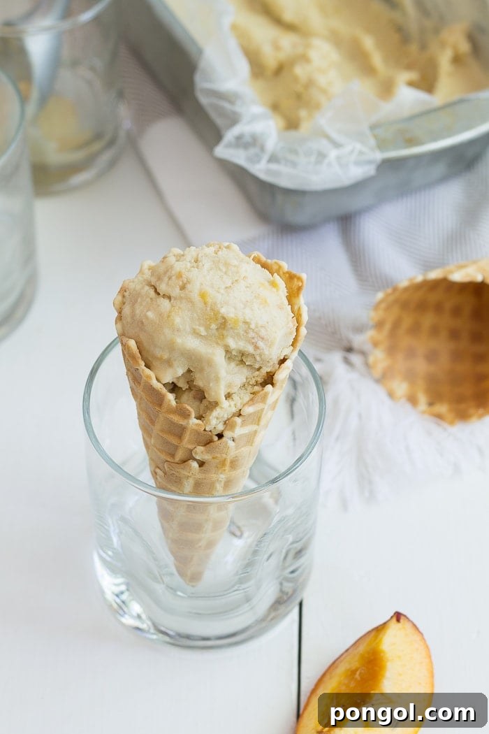 Sun-Kissed Vegan Peach Bliss 9 Overhead shot of vegan peach ice cream in a bowl with fresh peach slices, showcasing its delightful presentation.