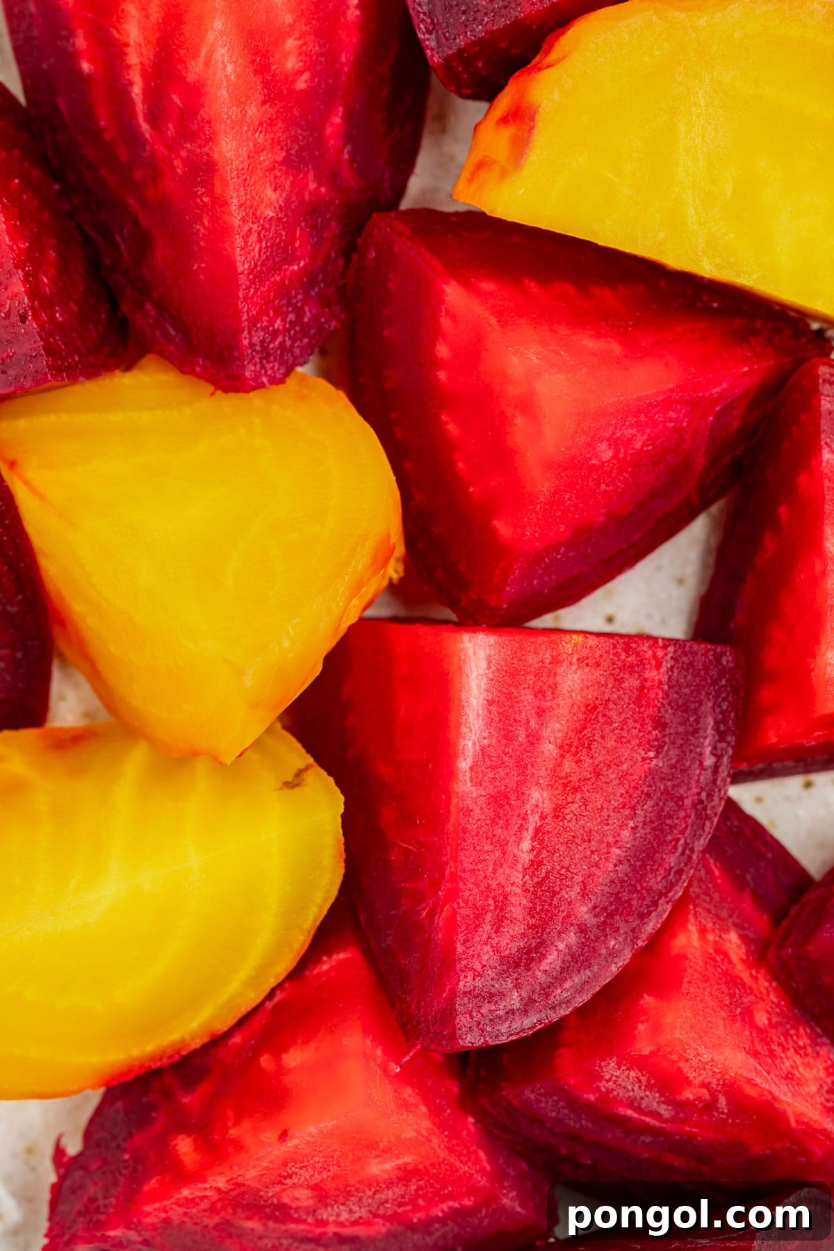Close up of red and golden beets cut into large chunks, ready for cooking.