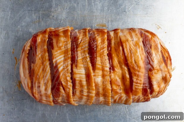 Bacon wrapped meatloaf on baking sheet