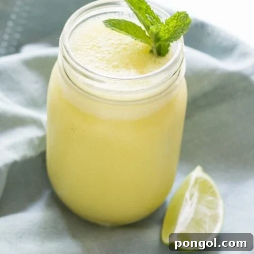 Mango Mojito Smoothie, garnished with mint, perfect for a sunny day.