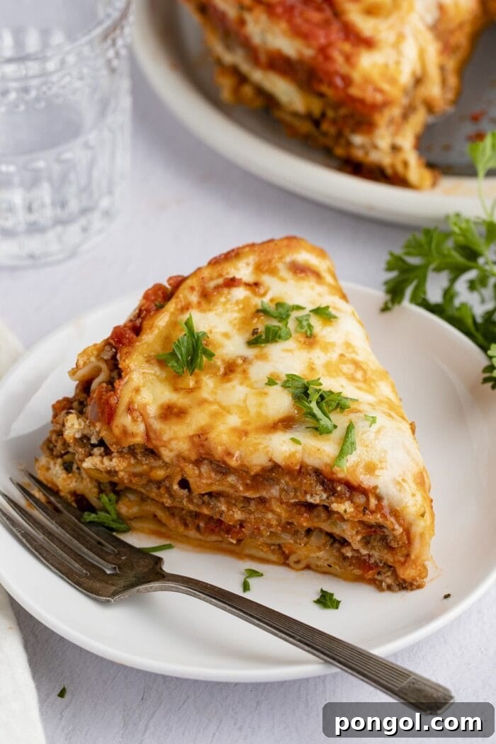 A wedge slice of Instant Pot lasagna on a white plate, showcasing its delicious layers.