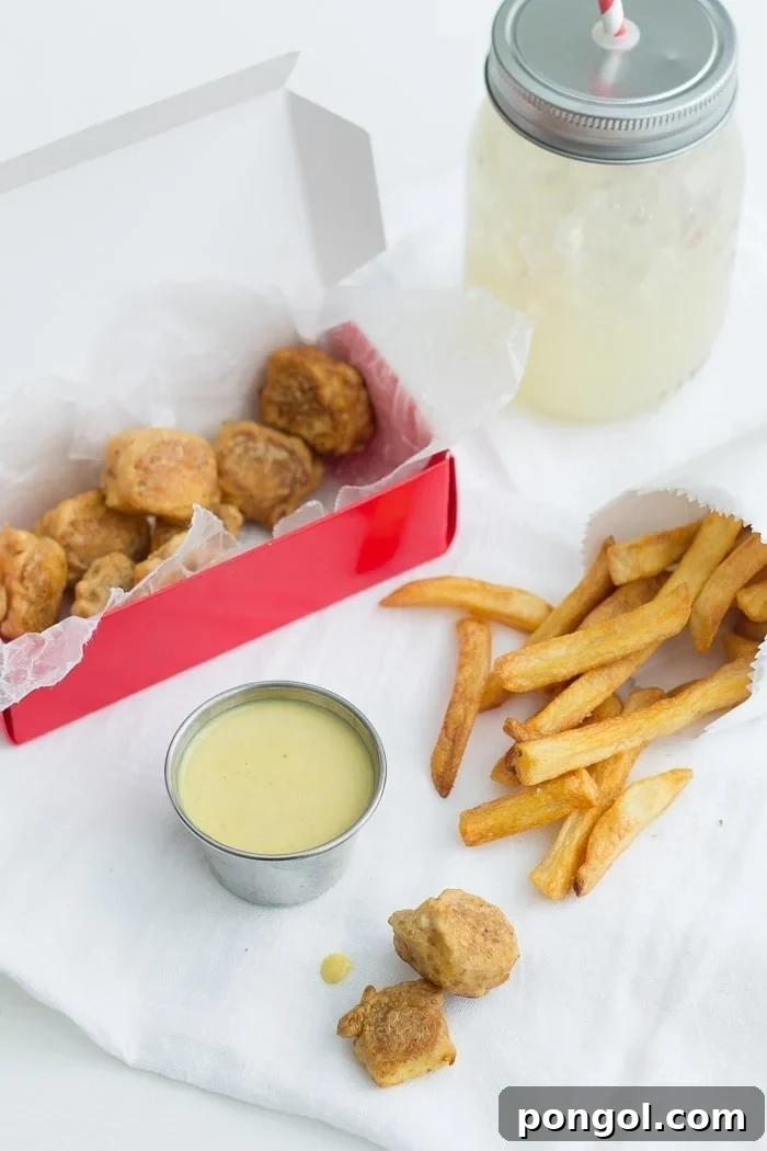 A spread of vegan Chick-fil-A Tofu Nuggets with a side of vegan honey mustard and homemade lemonade.