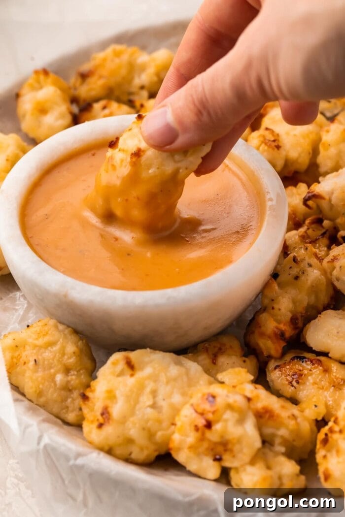 An air fryer chicken nugget dipped into copycat Chick-fil-a sauce
