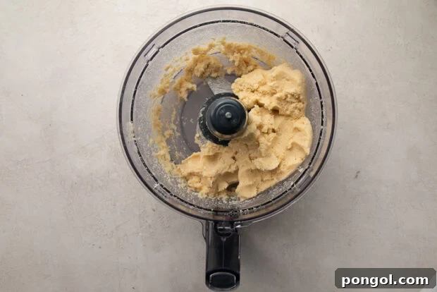 Keto Comfort Chicken Pot Pie 6 Keto pie crust dough in food processor bowl, showing a crumbly texture.