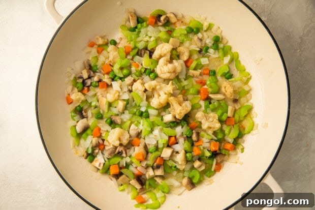 Keto Comfort Chicken Pot Pie 8 Mixed vegetables for keto chicken pot pie filling sautéing in a large skillet.