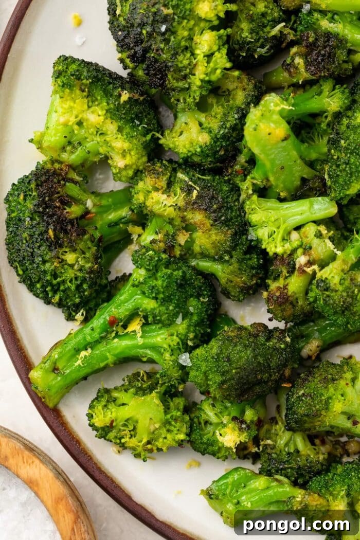 Sautéed Broccoli Florets 2 Sauteed broccoli on a white plate, garnished with lemon zest