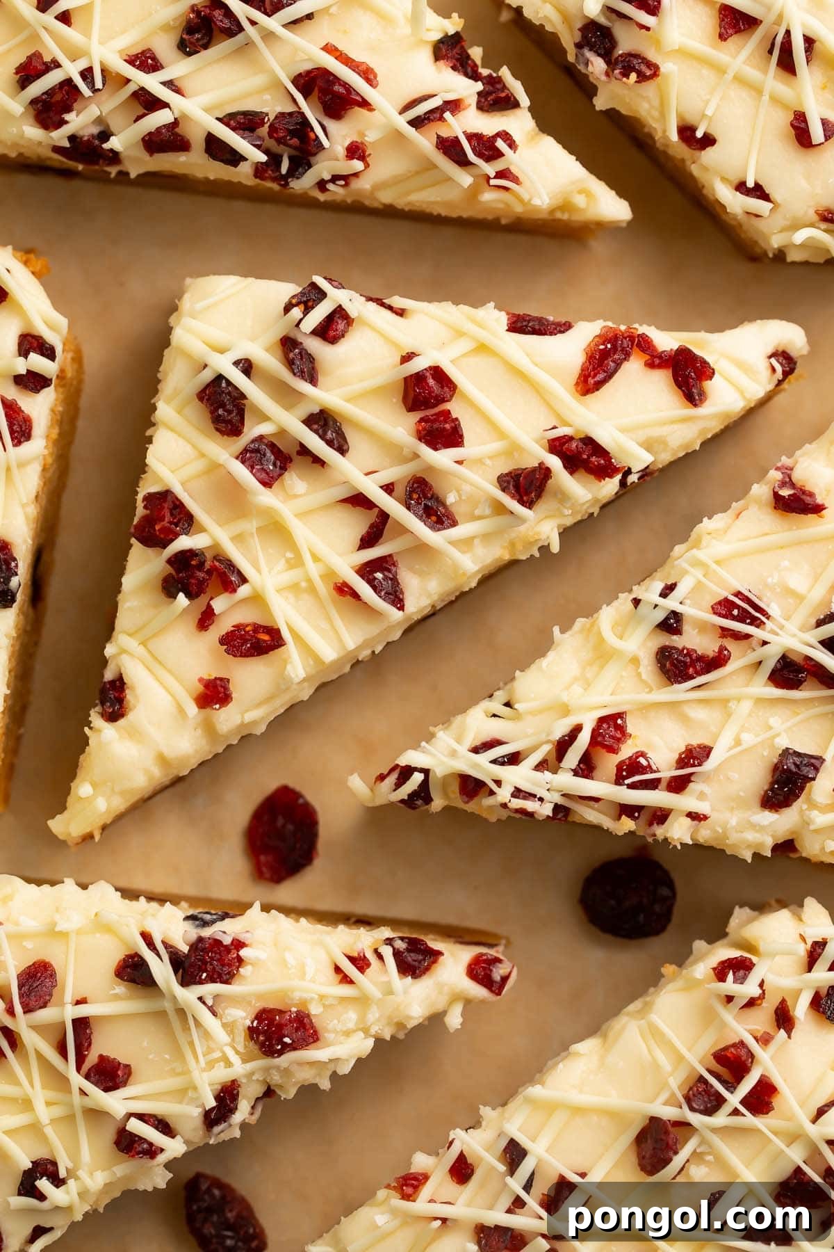 A plate of homemade Cranberry Bliss Bars, topped with cream cheese frosting and dried cranberries.