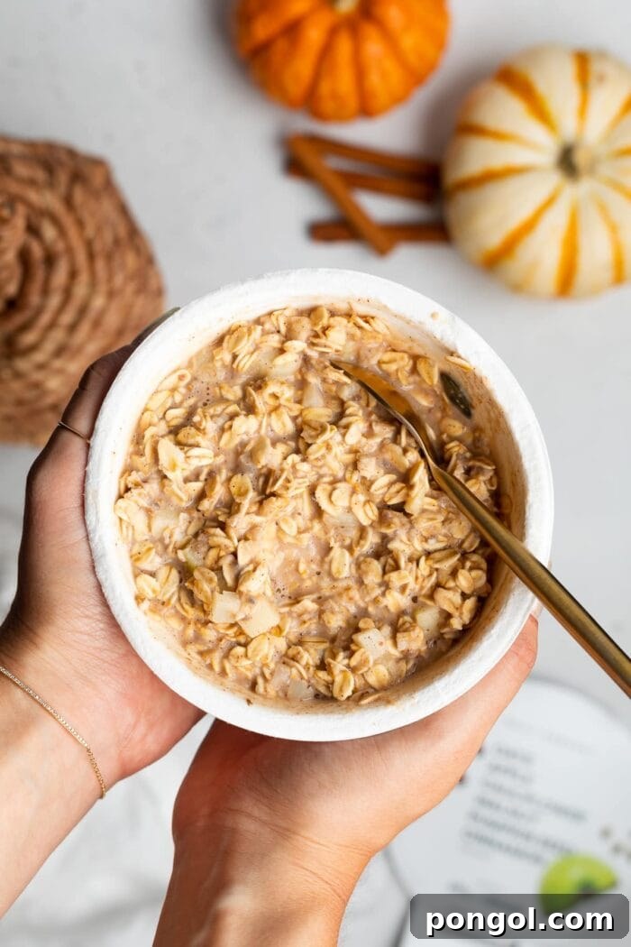 Daily Harvest: Embracing Autumn with Organic Eats 2 Daily Harvest oat bowl held in two hands over a white tabletop with pumpkins in the background