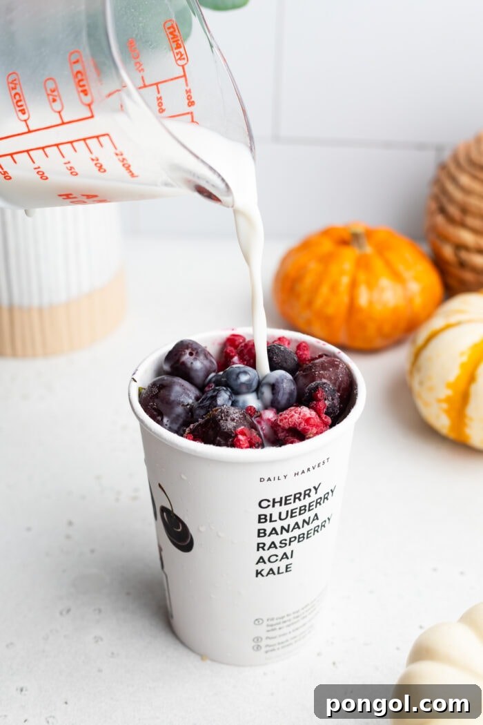 Daily Harvest: Embracing Autumn with Organic Eats 10 Milk poured into a smoothie cup of berries
