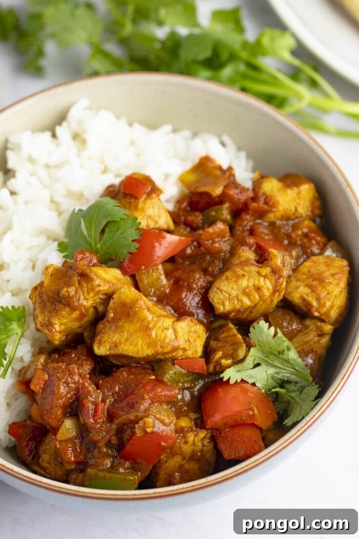 Vibrant and Fiery Chicken Jalfrezi 2 Chicken jalfrezi in a bowl with white rice, garnished with fresh cilantro