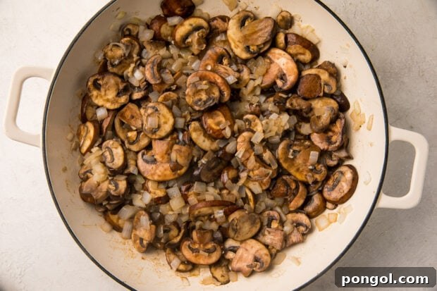Sautéed mushrooms and onions in a large skillet, perfectly browned and fragrant.