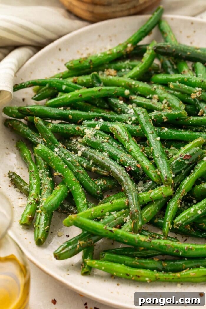 Close up photo of flavorful Italian green beans on a plate, garnished with fresh herbs.