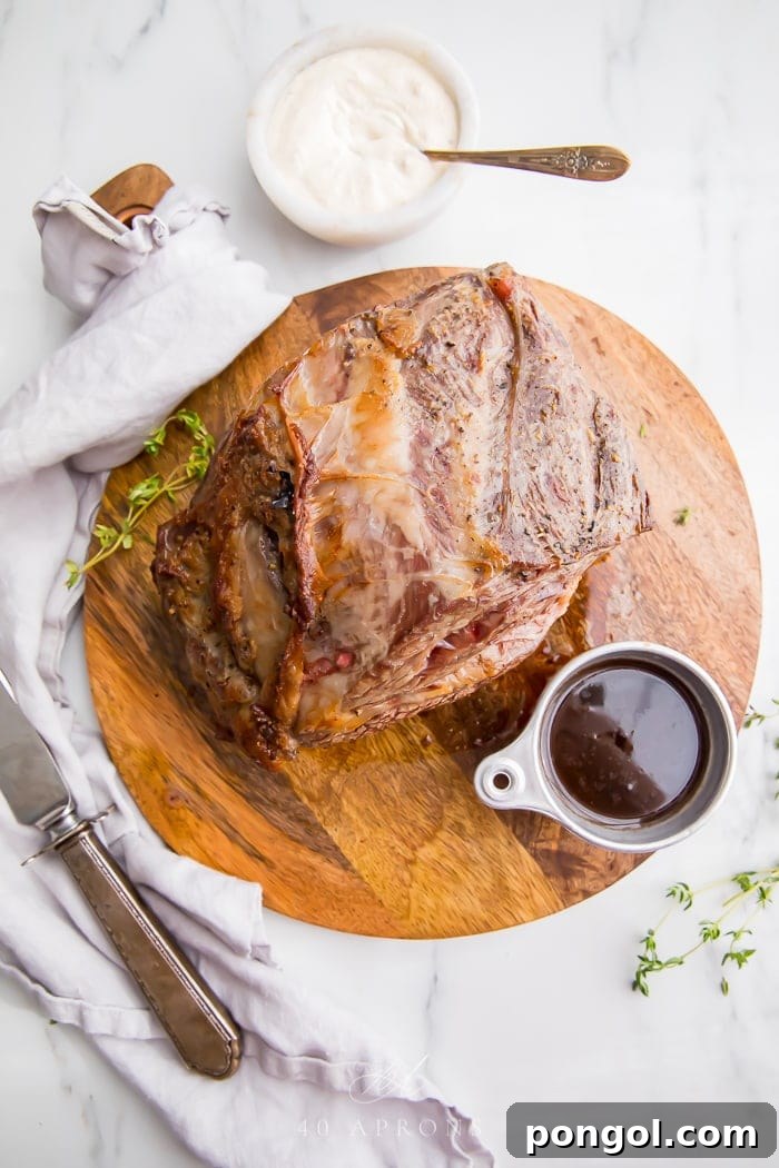 Prime rib served with a generous pour of rich au jus in a gravy boat.