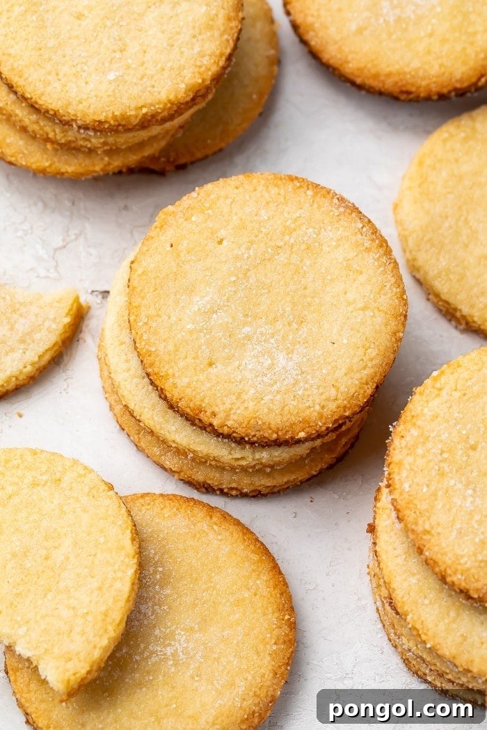 Stacks of golden keto shortbread cookies on a countertop, ready for serving.