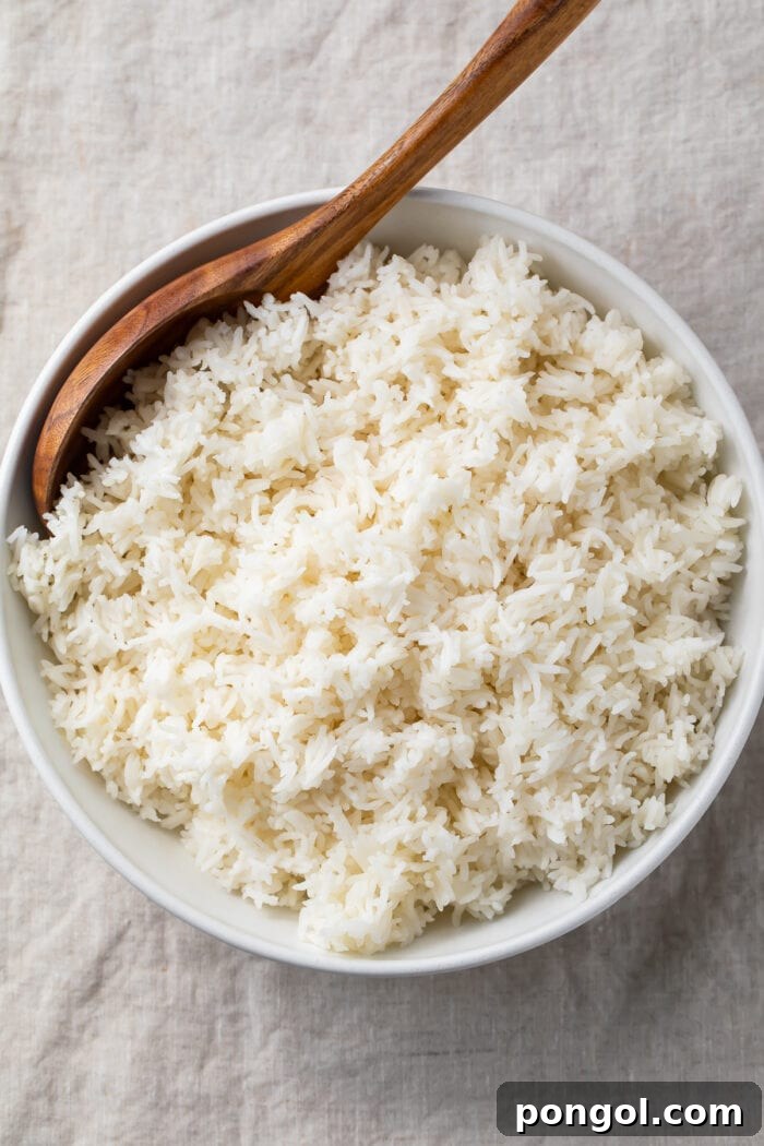 Overhead view of a large bowl of Instant Pot basmati rice with a wooden spoon on a table