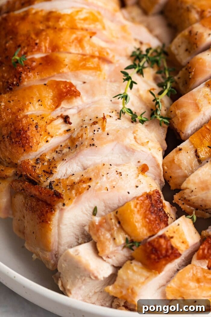 Juicy Sous Vide Turkey Breast with Golden Crispy Skin 2 Close-up image of beautifully sliced sous vide turkey breast garnished with fresh thyme, showcasing its tender texture.