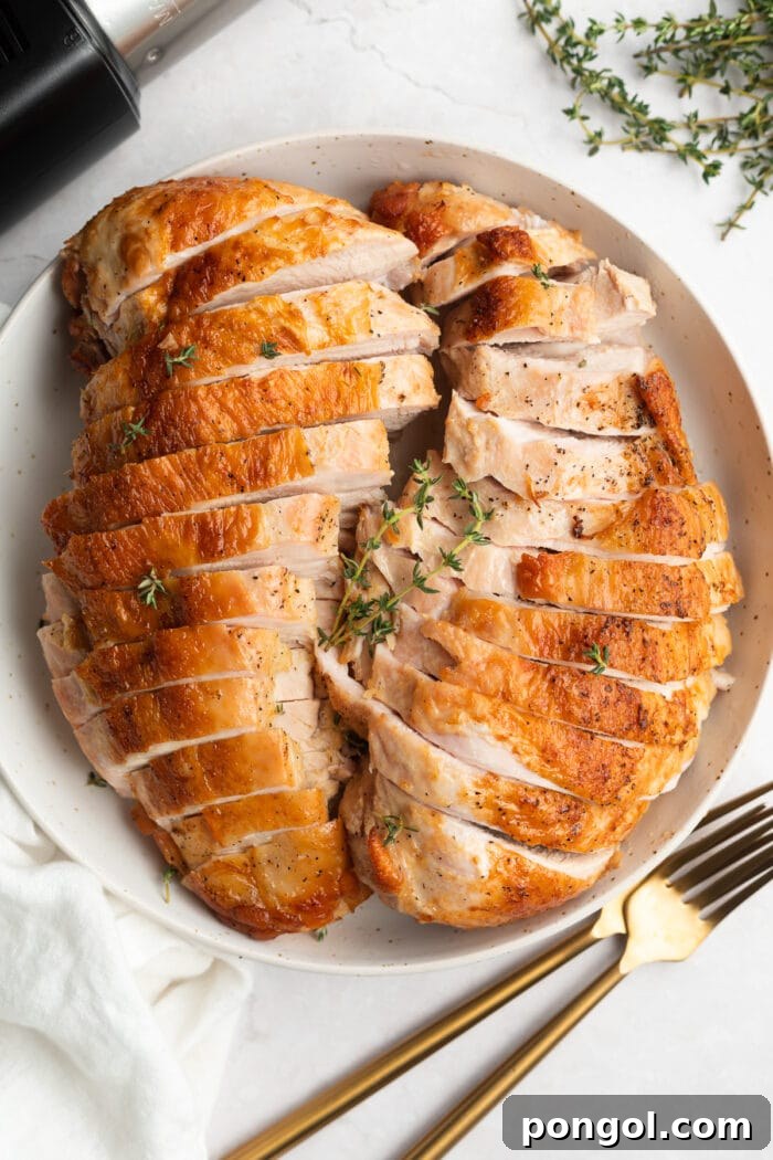 Juicy Sous Vide Turkey Breast with Golden Crispy Skin 3 Overhead shot of perfectly cooked sous vide turkey breast on a serving plate, ready to be carved, with the sous vide immersion circulator visible in the background.