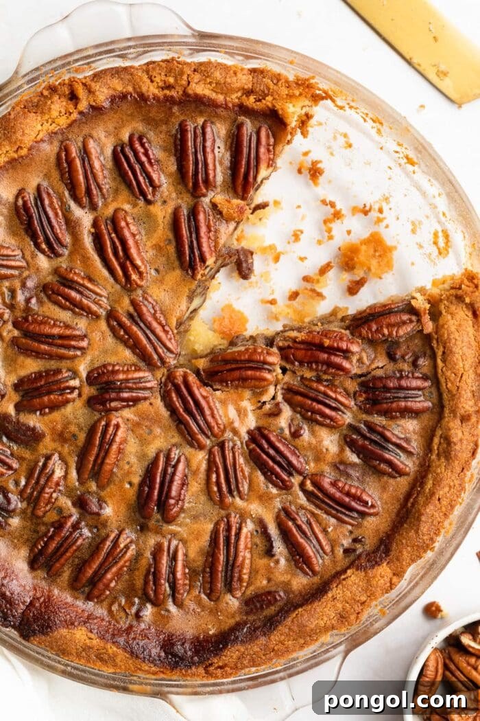 Decadent Keto Pecan Pie 2 keto pecan pie in a pie dish with a slice removed