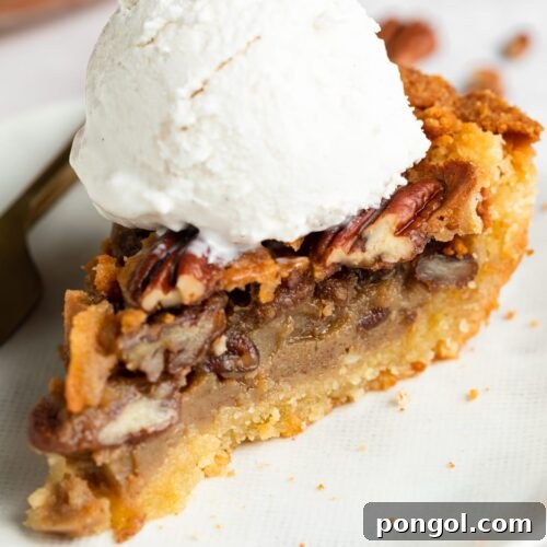 slice of keto pecan pie on a plate with sugar-free vanilla ice cream on top
