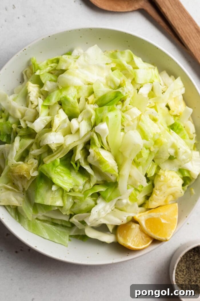 sauteed cabbage in a bowl with serving spoons on the side